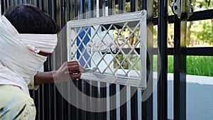 Painter hand on silver painting on black enter gate. Painting metal fence parts using pain brush. Worker hand with tool closeup