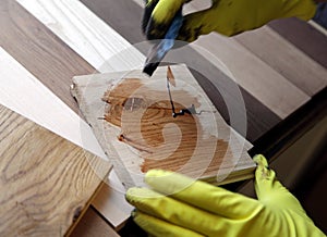 Painter holding a paintbrush over wooden surface