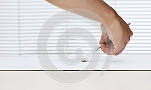 Painter man hand with paint brush painting on white board, house