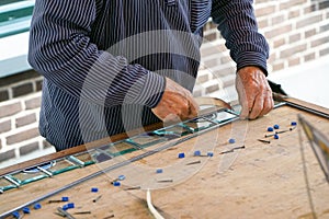 Painter man makes stained glass.