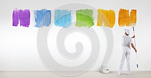 Painter man painting varied colors symbol isolated on wall photo