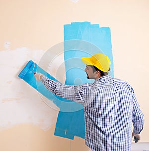 Painter man painting the wall at home