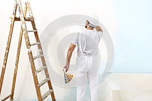 Painter man at work with color swatches samples, wall painting