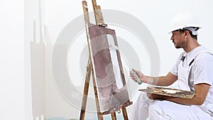 Painter man at work with paint roller, easel, canvas and palette, wall painting concept, white background