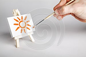 Painter painting a sun on a small array