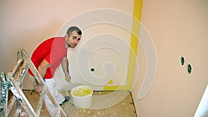 Painter Painting a Wall with a Paint Roller