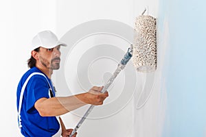 Painter painting a wall with paint roller