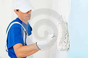 Painter painting a wall with paint roller