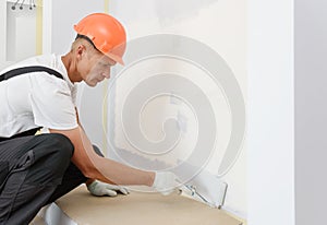 The painter is painting a wall with a roller