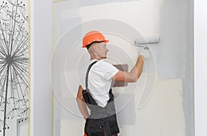 The painter is painting a wall in a room