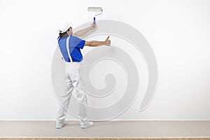 Painter with paintroller doing ok on white wall photo