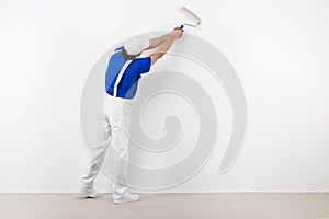 Painter with paintroller on white wall photo