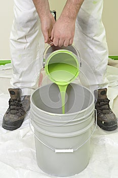 Painter pouring green paint