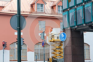 Painter with roller painting house facade in town