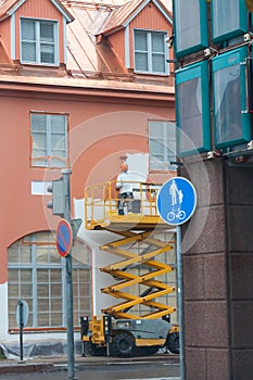 Painter with roller painting house facade in town