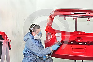 Painter spraying red base.