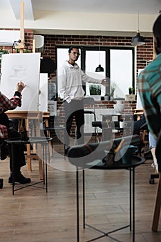 Painter students creating sketching artwork on canvas using graphic pencil