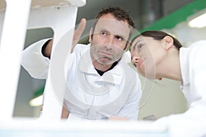 painter teaching paintbrush technique to apprentice