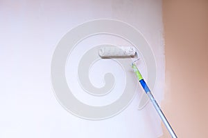 Painter use paint roller on wall with white stain. lifestyle close-up photo with copy sapce