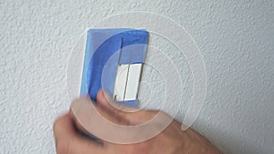 Painter Using Masking Blue Tape to Secure Electric Outlet. Preparation For Room Painting