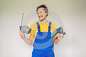 Painter in work clothes with a paint spray gun