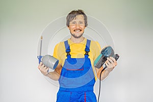 Painter in work clothes with a paint spray gun