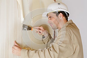 Painter worker peeling off wallpaper