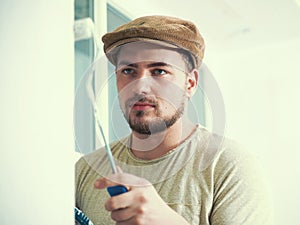 Painter working with paint roller and brushes to paint the room