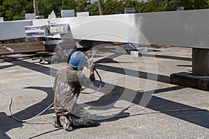 The painter is working to fireproof paint on steel structure with spray gun