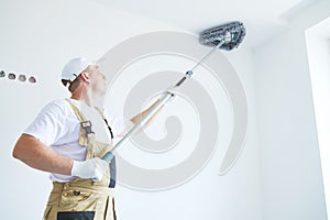 Painter works with triangle drywall cleaning tool. Surface preparation for painting