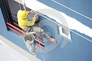 Painters hanging on roll, painting color on building wall photo