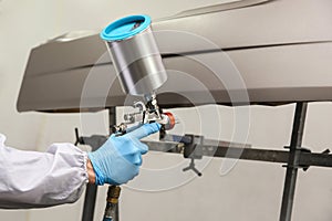 painting a car part in a spray booth by pulverizer close up