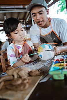 Painting ceramic pot in pottery workshop