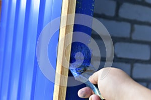 Painting the door with blue paint brush in hand