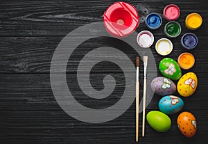 Painting eggs for Easter holiday on wooden table