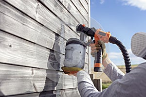 Painting fence or garden shed with a paint sprayer