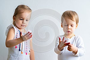 Painting is fun for kids - happy children play with the paint with dirty hands. Brother and sister playing with hands in