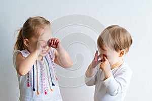 Painting is fun for kids - happy children play with the paint with dirty hands. Brother and sister playing with hands in