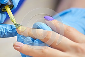 Painting nails with polish close up.