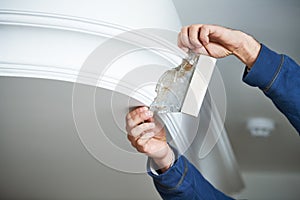 Painting and plasterwork. worker hand with spatula making molding