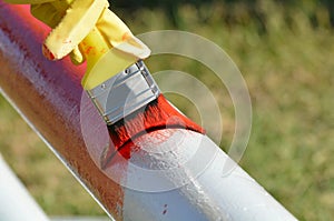 Painting a pole red with a brush