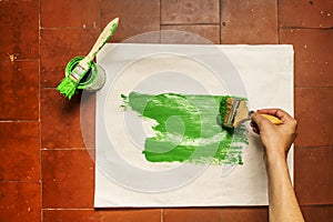 Painting a ream of paper with a pot of green