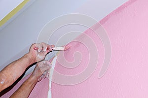 Painting wall of new apartment. painting voids after masking tape. hands in the paint photo