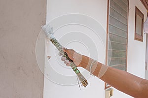 Painting walls.Painter paints using a brush,hand worker holding brush painting white on cement wall