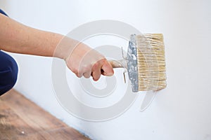 Painting the walls in the room using paint roller