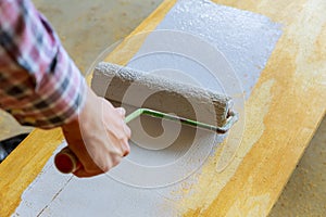 painting the wood with white paint roller