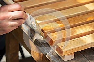 Painting wooden furniture with varnish. a man hides a tree with varnish.