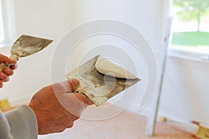 Painting worker puttied wall using a paint spatula hand.