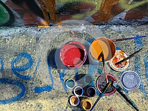 Painting and writing on a public wall, making graffiti in the street with colorful cans of paint_street art concept