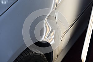 Paintless dent on white car photo